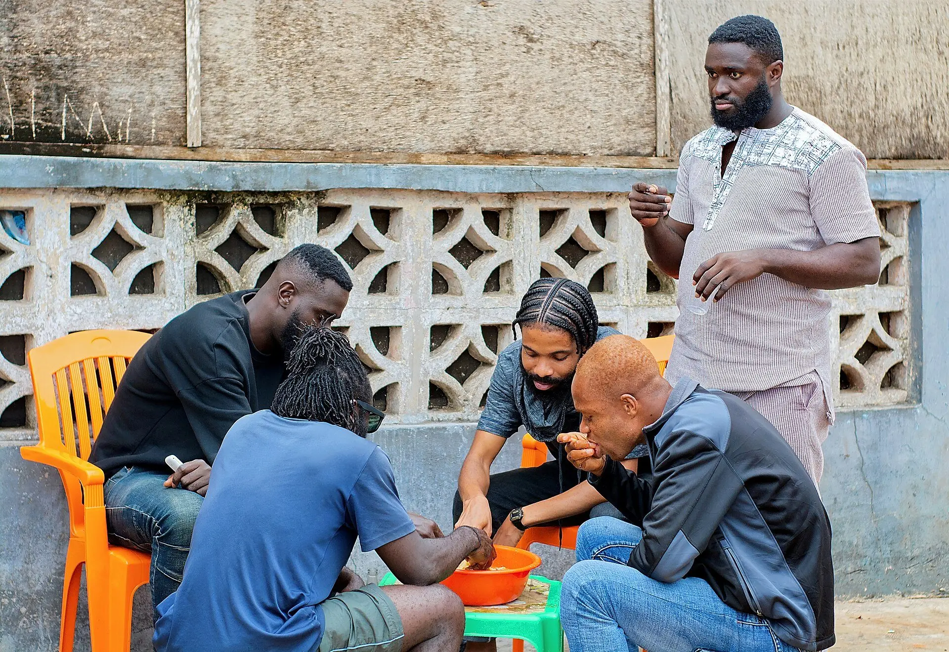 A group of friends sharing a meal around a small table outdoors